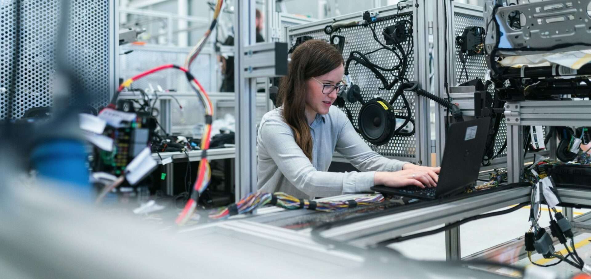 Una mujer trabaja en su ordenador en un espacio de trabajo industrial