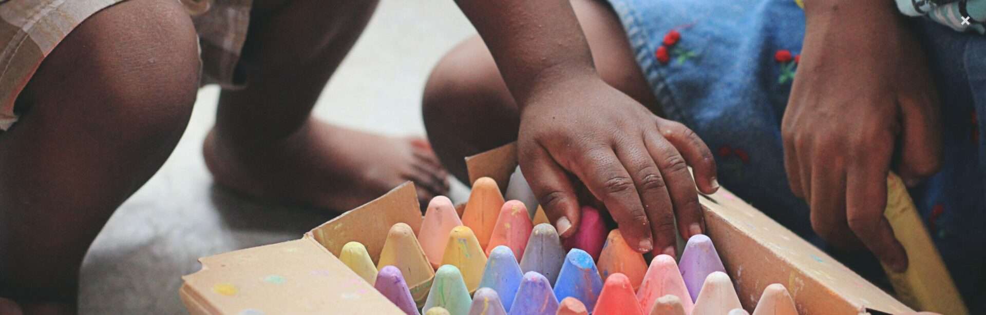 Niños pequeños juegan con tizas de colores